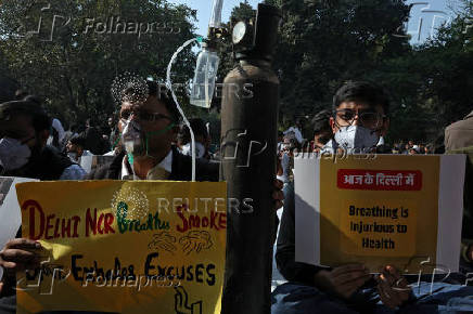 Demonstrators hold placards and wear masks during a protest demanding government to take immediate steps to control air pollution