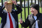 A tourist pays a tip to Donald Trump impersonator Ed Weiskopf after posing for a photo in front of the White House in Washington