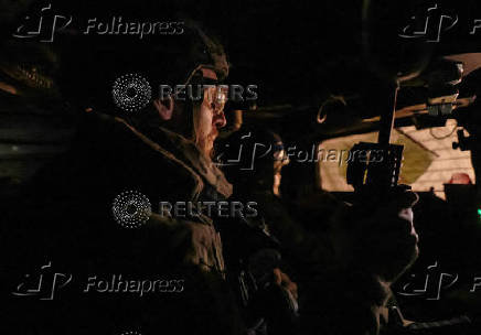 Servicemen of the Ukrainian Armed Forces ride a military vehicle at a front line in Donetsk region