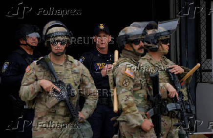 California National Guard troops stand outside the Edward R. Roybal federal building, in Los Angeles