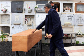 Mayor of Valverde, Carlos Brito, with a doll in his hand, stands next to the coffin of 12-year-old migrant girl Fatoumatta Banaro during her burial, in El Hierro