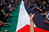 Shi'ite mourners carry a Palestinian flag to show solidarity during a Muharram procession ahead of Ashura in Srinagar