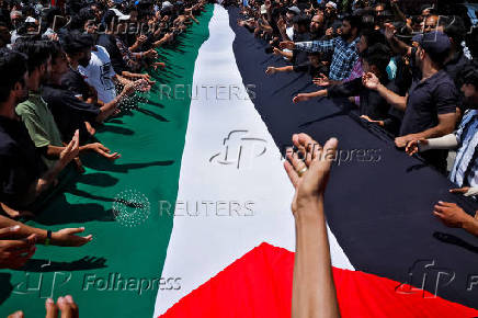 Shi'ite mourners carry a Palestinian flag to show solidarity during a Muharram procession ahead of Ashura in Srinagar