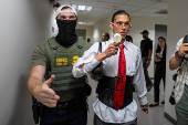 A migrant is detained by federal immigration officers at U.S. immigration court