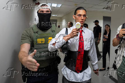 A migrant is detained by federal immigration officers at U.S. immigration court