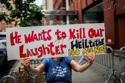 People take part in a protest in front of the CBS broadcast center in New York