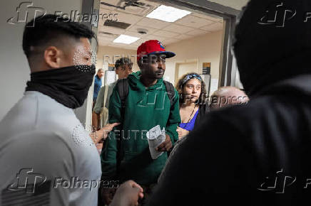A migrant is detained by federal immigration officers at U.S. immigration court