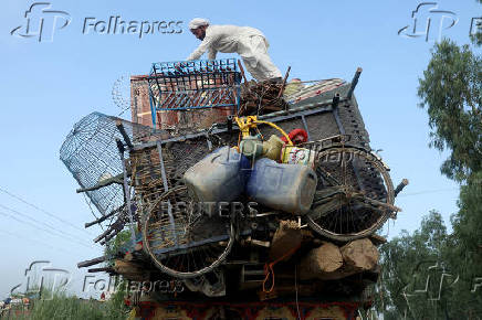 An Afghan man loads his belongings onto a truck as he prepares to leave, after Pakistan started to deport documented Afghan refugees, outside the United Nations High Commissioner for Refugees (UNHCR) repatriation centre in Nowshera