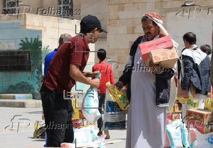 Yemenis receive food aid in Sana'a, distributed by Mona Relief agency