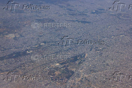 An aerial view through the window of a passenger aircraft shows the city of Athens and the peripheral cities, Greece