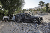 People gather near a damaged site, in Damascus
