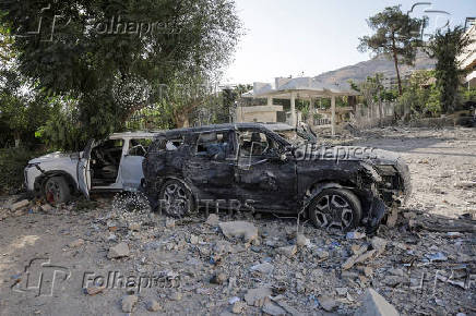 People gather near a damaged site, in Damascus