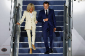 French President Emmanuel Macron and his wife, Brigitte Macron disembarks from the plane upon their arrival at military airbase Halim Perdanakusuma in Jakarta