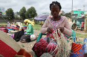 Grace Muinde weaves sisal and recycled polythene to make a traditional handwoven basket known as Kiondo at the Mwariro Market in Kariokor district of Nairobi