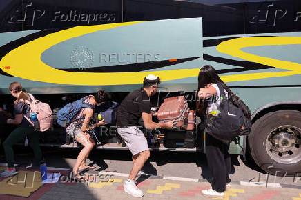 Passengers, who had left Israel on Tuesday aboard the Crown Iris cruise ship due to the closure of Israel's airspace amid the Israel-Iran conflict, board a bus after their arrival at the port of Larnaca