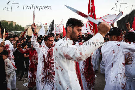 Volunteers re-enact a scene from the 7th-century Battle of Karbala to commemorate Ashura in Baghdad