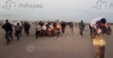FILE PHOTO: Palestinians carry aid supplies received from the U.S.-backed Gaza Humanitarian Foundation, in Rafah
