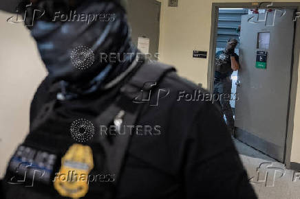 A migrant is detained by federal immigration officers at U.S. immigration court