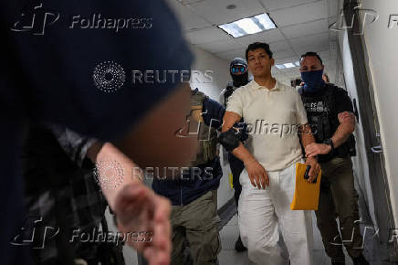 A migrant is detained by federal immigration officers at U.S. immigration court