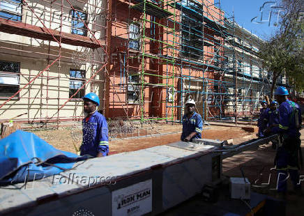Construction workers arrive for a shift to renovate nurses' hostels, at Parirenyatwa Group of Hospitals, a major referral hospital in Harare