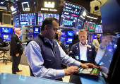 Traders work on the floor at the New York Stock Exchange, in New York City