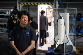 Innovative Space Carrier CEO Hatada poses with a ASCA 3 planned spaceplane model, in Yokohama
