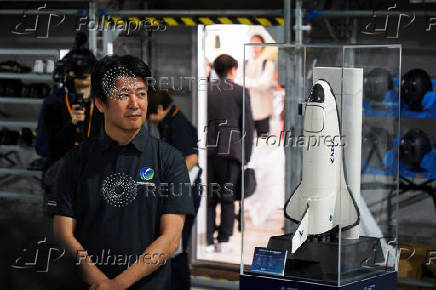 Innovative Space Carrier CEO Hatada poses with a ASCA 3 planned spaceplane model, in Yokohama