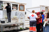 People hug the mother of 12-year-old migrant girl Fatoumatta Banaro during her burial, after the wooden boat she was traveling on sank in the port of La Restinga