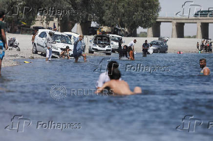 People enjoy in the Euphrates River during a hot day in Raqqa