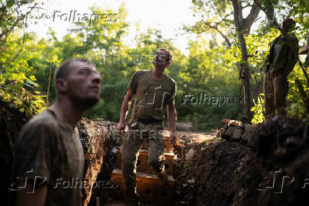 Ukrainian servicemen look out for Russian combat drones at a position on a front line near the city of Kostiantynivka