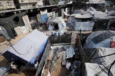 Palestinians inspect the damage following an overnight Israeli strike on a school sheltering displaced families, in Jabalia