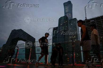 People walk on a terrace of a shopping mall at the central business district (CBD), in Beijing