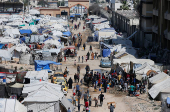 Displaced Palestinians fill water at a tent camp, in Gaza