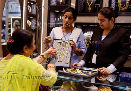 FILE PHOTO: A customer looks at gold chains at a jewellery store in Mumbai