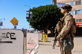A U.S. Marine stands guard outside the Edward R. Roybal Federal Building, in Los Angeles