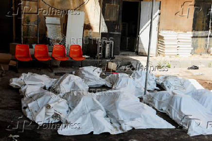 Covered bodies lie on the ground in Sweida