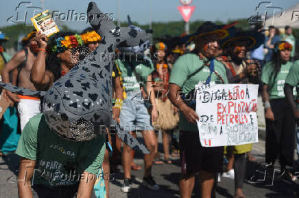 FILE PHOTO: A man wears a mask depicting a whale attends a protest against an oil block auction in Rio de Janeiro