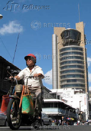 FILE PHOTO: A Mauritian rides his motorbike past Mauritius' central bank in the capital Port Louis