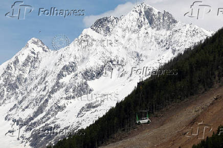 A car is carried by helicopter near Blatten