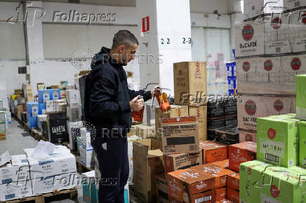 FILE PHOTO: A liquor store employee unboxes U.S bourbon bottles in Athens