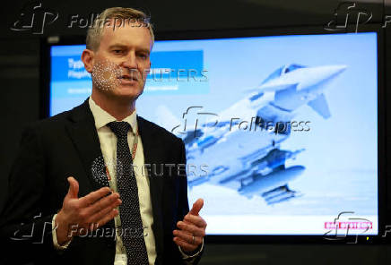 Richard Hamilton, Director for Europe and international in the Air sector of BAE Systems, gives a presentation in front of an image of one of their Typhoon military jets at their Warton factory in Warton