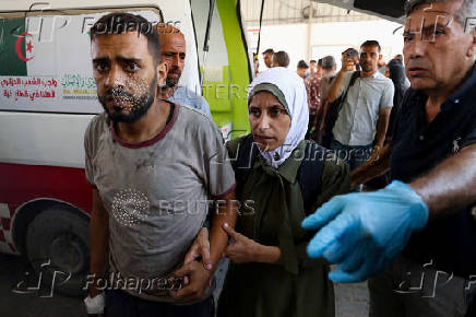 Palestinians transport casualties of Israeli fire, who were seeking aid in northern Gaza, according to medics, in Gaza City
