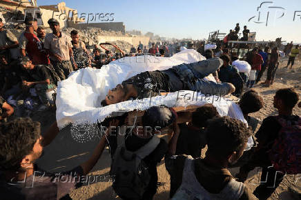 Palestinians carry aid supplies that entered Gaza through Israel, in Beit Lahia