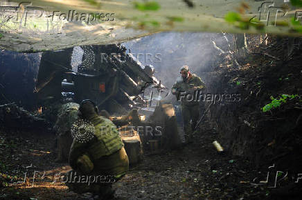 Ukrainian servicemen fire a self-propelled howitzer towards Russian troops at a frontline near the town of Chasiv Yar