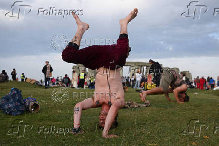 Revellers attend summer solstice celebrations during sunrise at Stonehenge near Amesbury