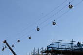 A construction worker takes a break under cable car cabins in Singapore