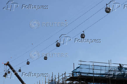 A construction worker takes a break under cable car cabins in Singapore