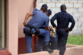 Police officers inspect the scene where kidnapped U.S. pastor, Josh Sullivan, was rescued last night in a shootout during which three suspects were killed, in KwaMagxaki