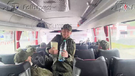 Russian soldiers pose for cameras in Belarus after release from Ukraine on second day of POW exchange