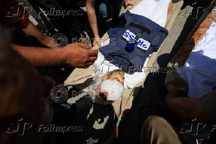 Mourners carry the body of a Palestinian journalist Ismail Baddah, who was killed in an Israeli airstrike on Al-Ahli Arab Hospital, in Gaza City